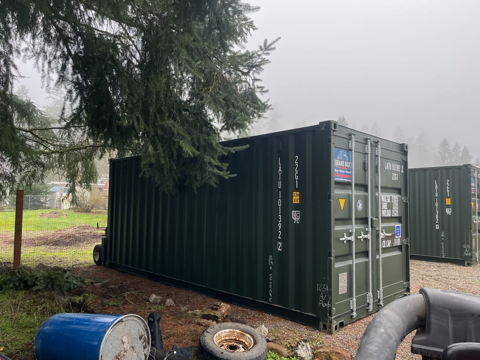 Dark green shipping containers installed in a foggy wooded area - Grand Box Northwest